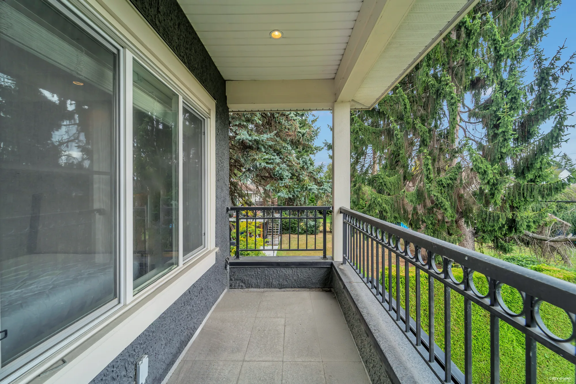 The balcony from its door, the tiled floor and the railing