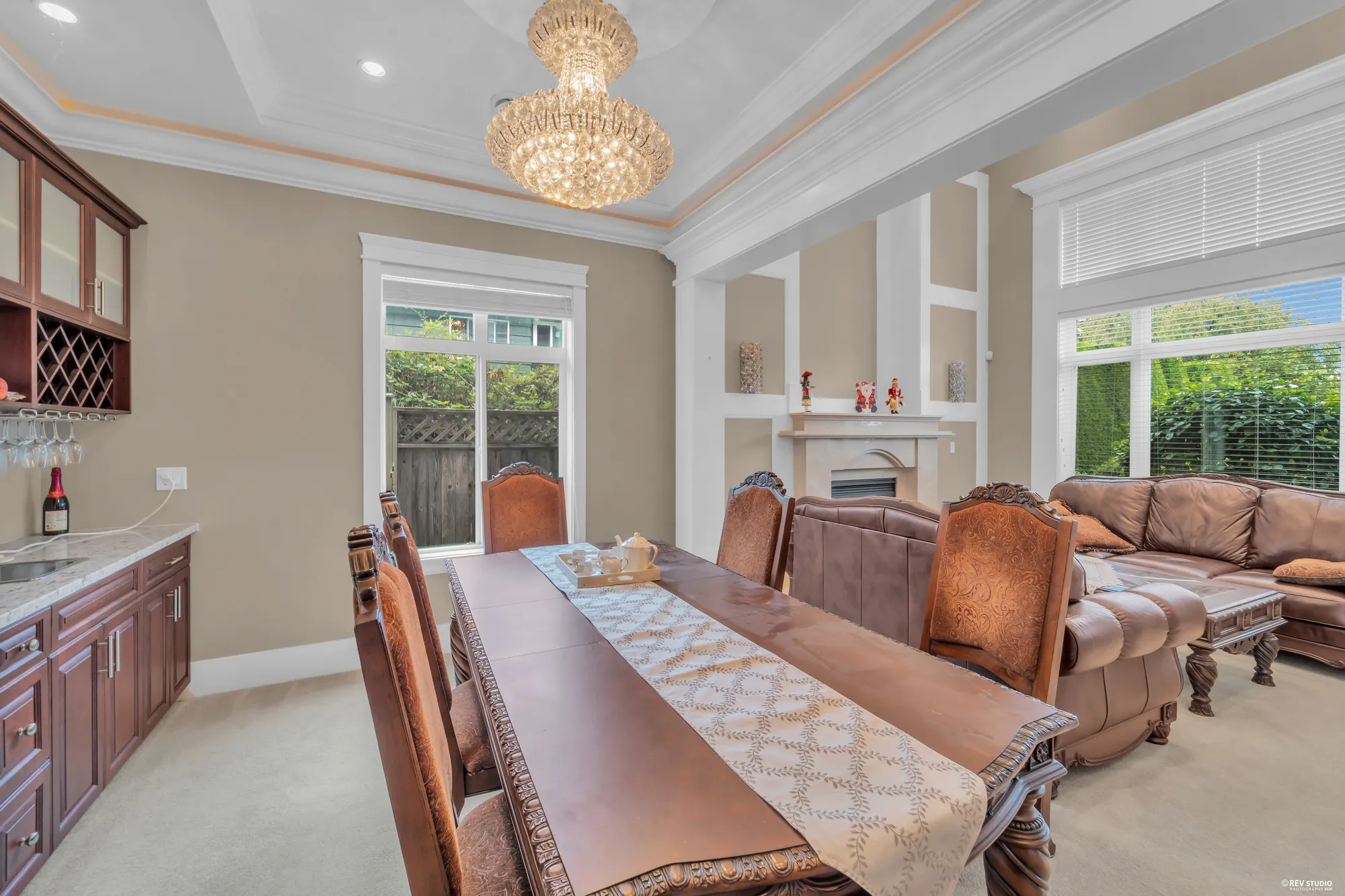 The dining table toward the living room and its windows, a glazed cabinet at left