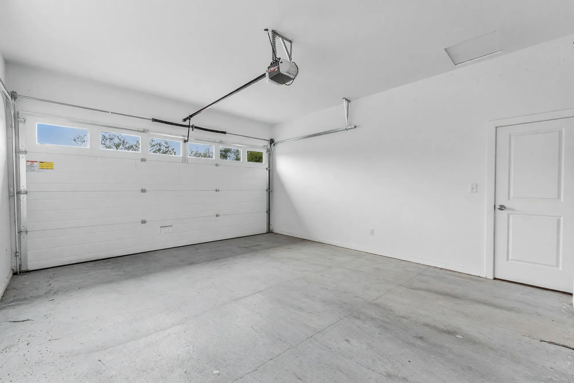 Inside the double garage: a concrete floor, the door with its windows, the door into the house