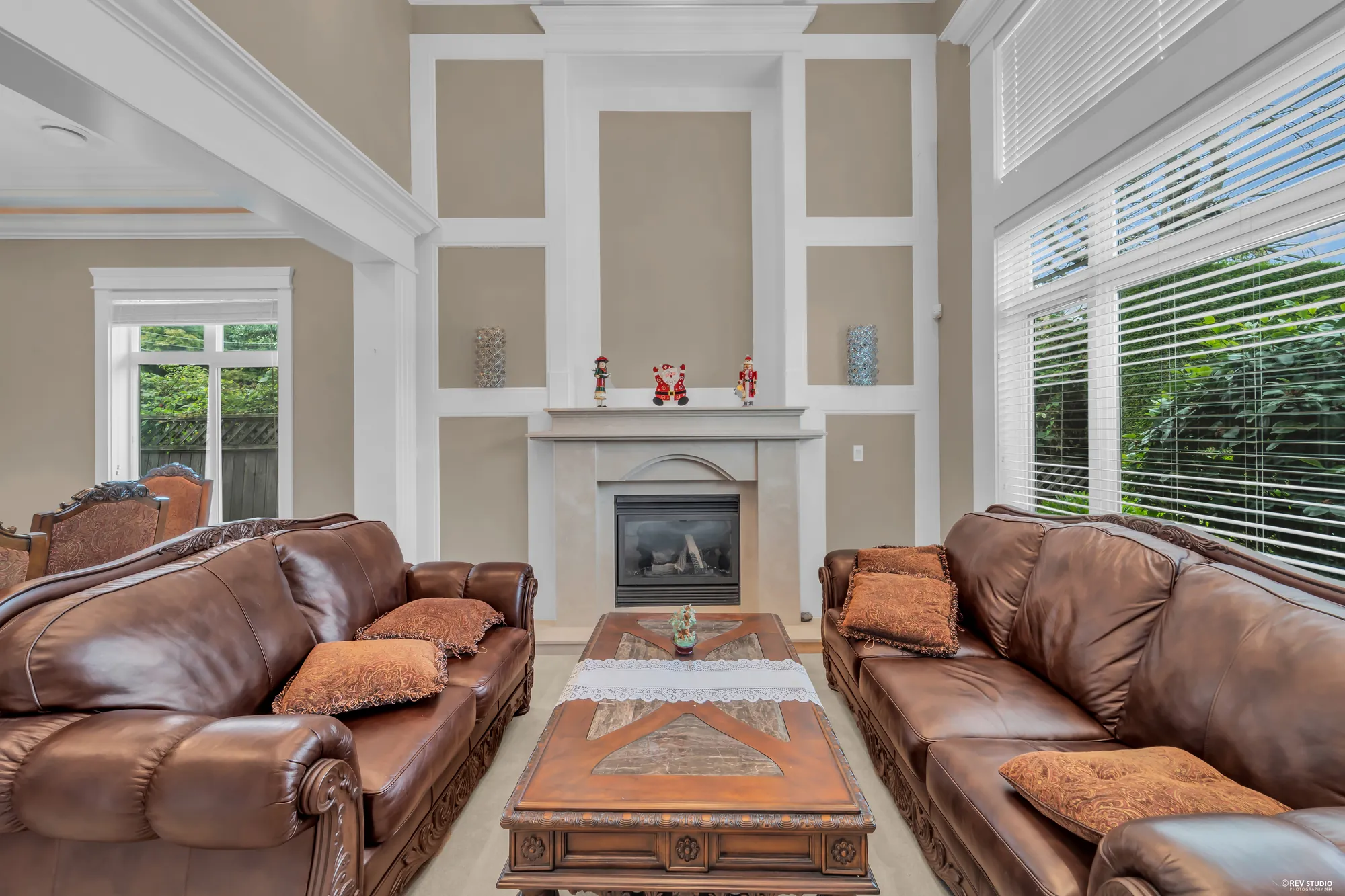 The fireplace wall from the sofas, the tall window at right