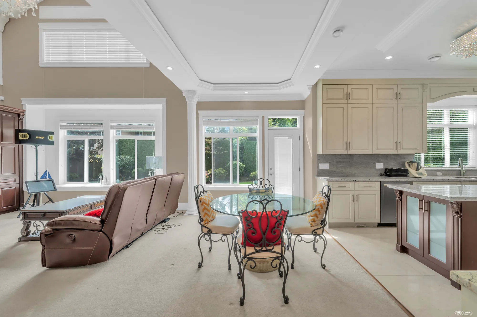 The breakfast nook: a round glass table by the doors to the garden, the family room's sofa at left
