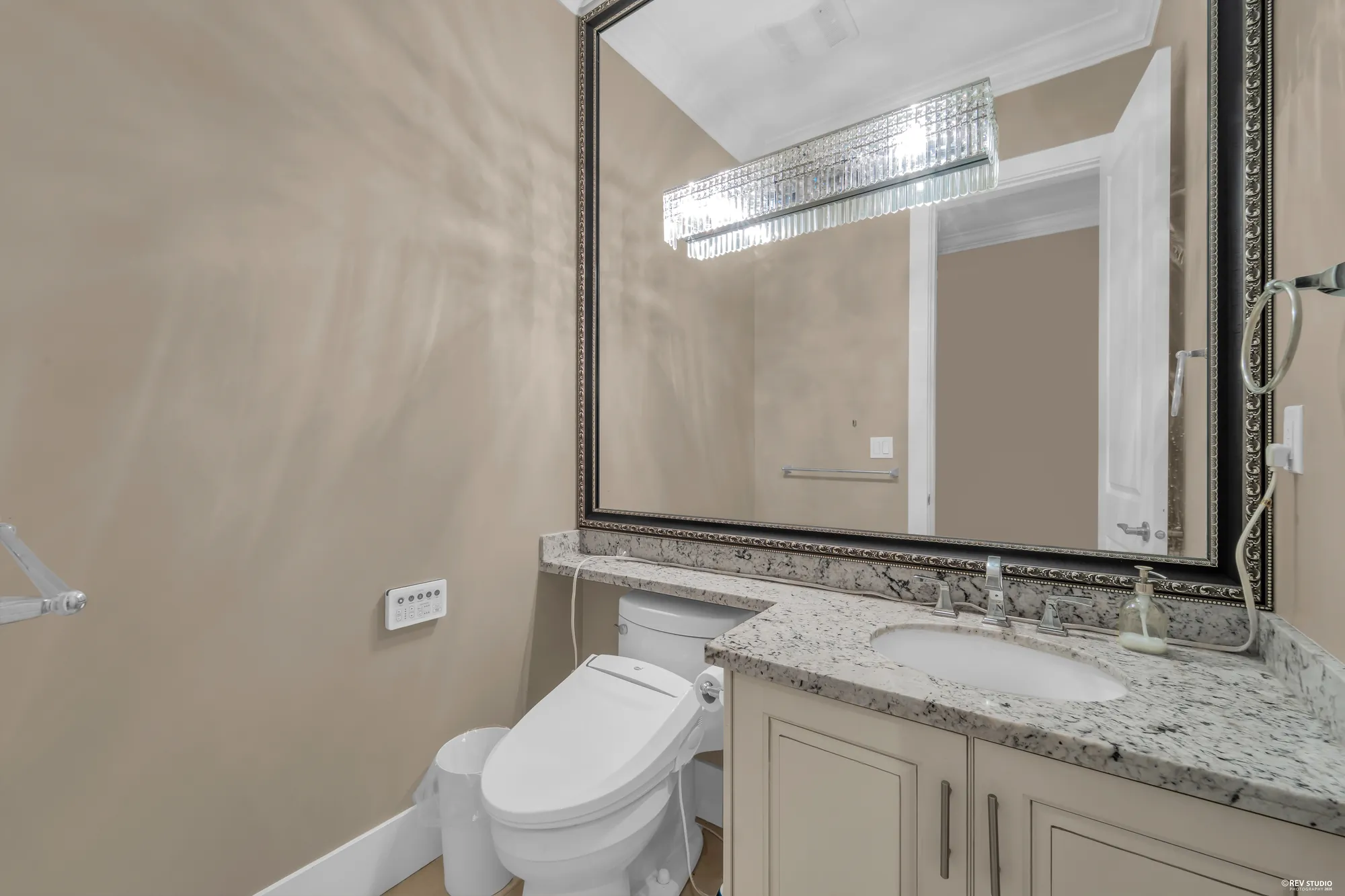 The powder room: a granite vanity under a wide framed mirror