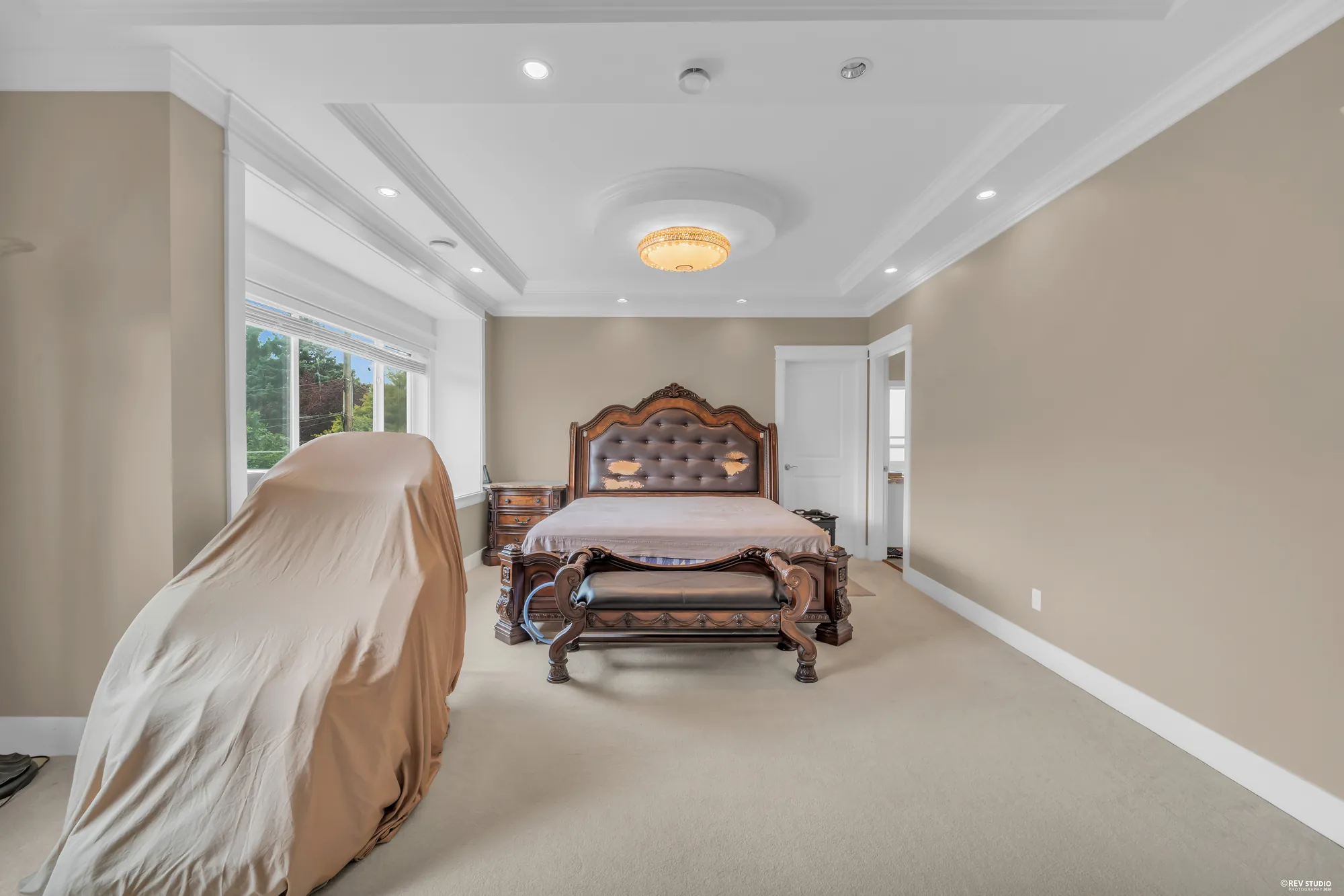 The bed wall of the primary bedroom, the door to the bathroom at right